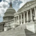 The United States Capitol building under a partly cloudy sky.