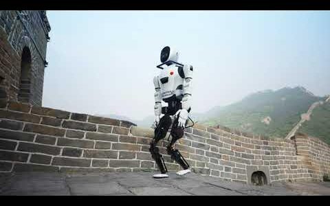 A robot is walking along the Great Wall of China under a hazy sky.